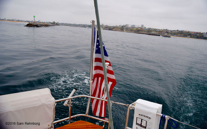 A view over the Double X stern as it motors out of Newport Jetty in the early morning. The ship’s flag is limp, signaling calm winds needed for good motoring conditions, Newport Beach, Calif., June 14, 2016.