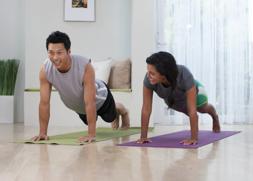 A couple enjoying one of my favorite Pilates poses, the plank, which is a staple in my morning routine.