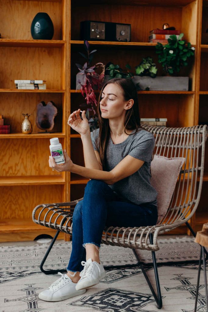 Young woman examining a Nutrilite™ product. Using the products is the first step in my six-step plan for business success.