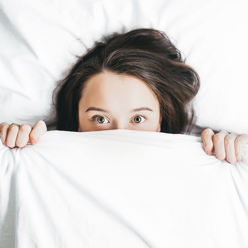 Woman wide awake in bed. If you have trouble sleeping, get out of bed and do a soothing activity that can help you get back to sleep.