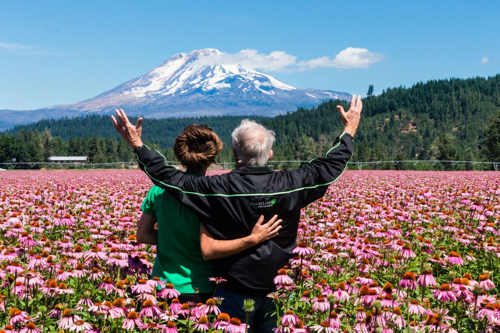 My daughter Koral and I stand in a field of echinacea in full bloom as we take in the majesty of snow-capped Mount Adams in the background. Our sustainable farming practices and modern farming technology keep these fields productive and fertile, season after season. Trout Lake Farm West, July 22, 2015. Photo: Darwin Hintz.