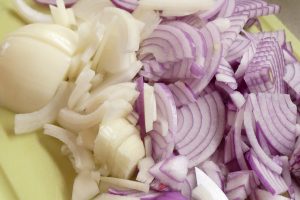 Diced white and red onions. Cutting onions before cooking releases alliinase, an enzyme needed to increase the level of sulfur compounds that have health benefits.