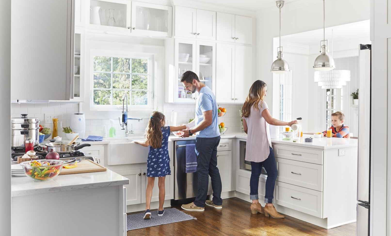A family busy preparing a meal. Making a habit of taking your Nutrilite™ supplement with a regular meal can help you remember to take them.